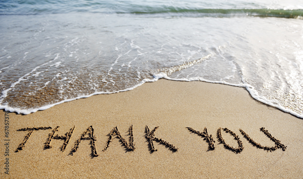thank you word drawn on the beach sand